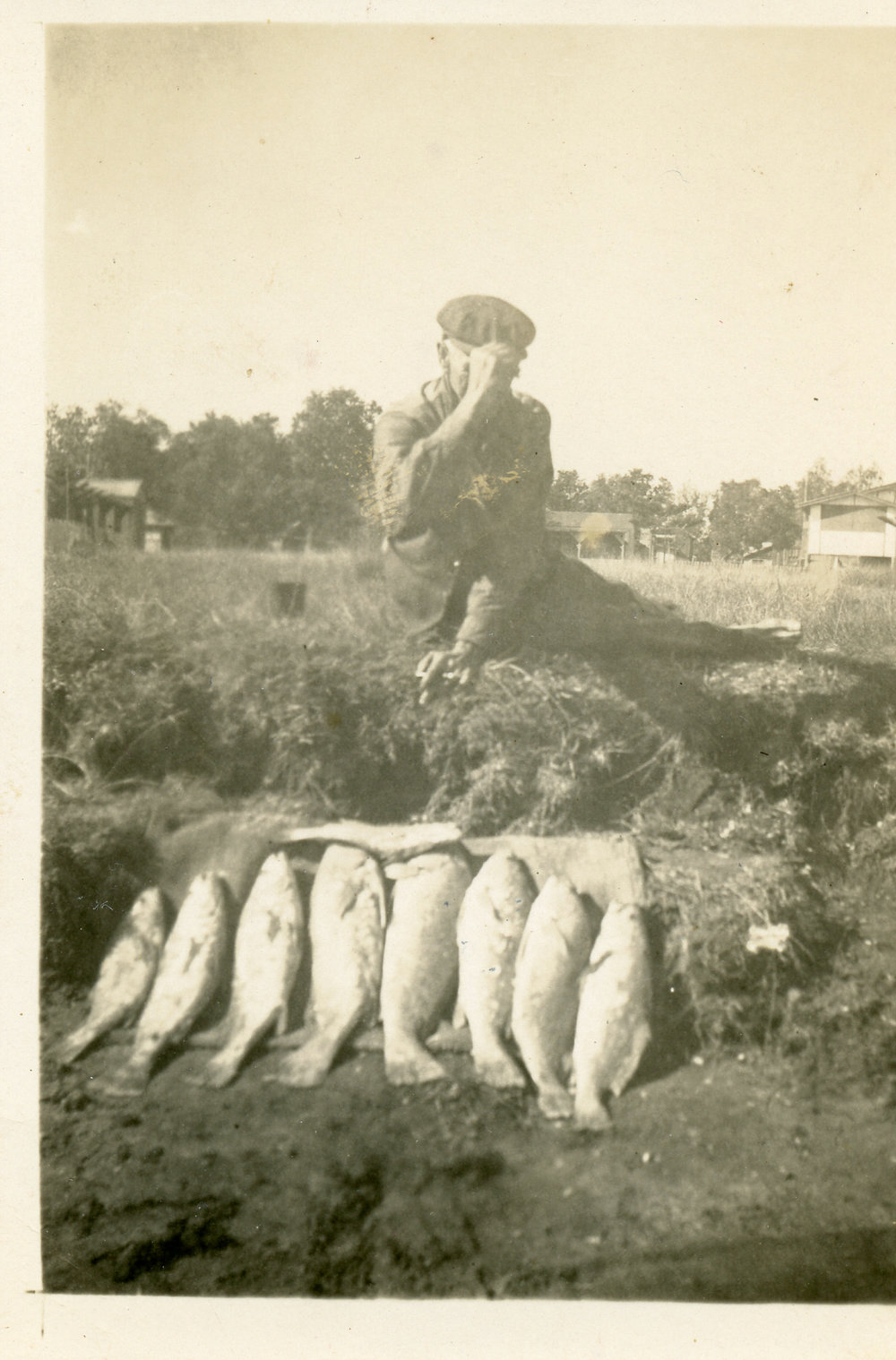 Fisherman with 8 fish on bank of river. Red Rock 1950