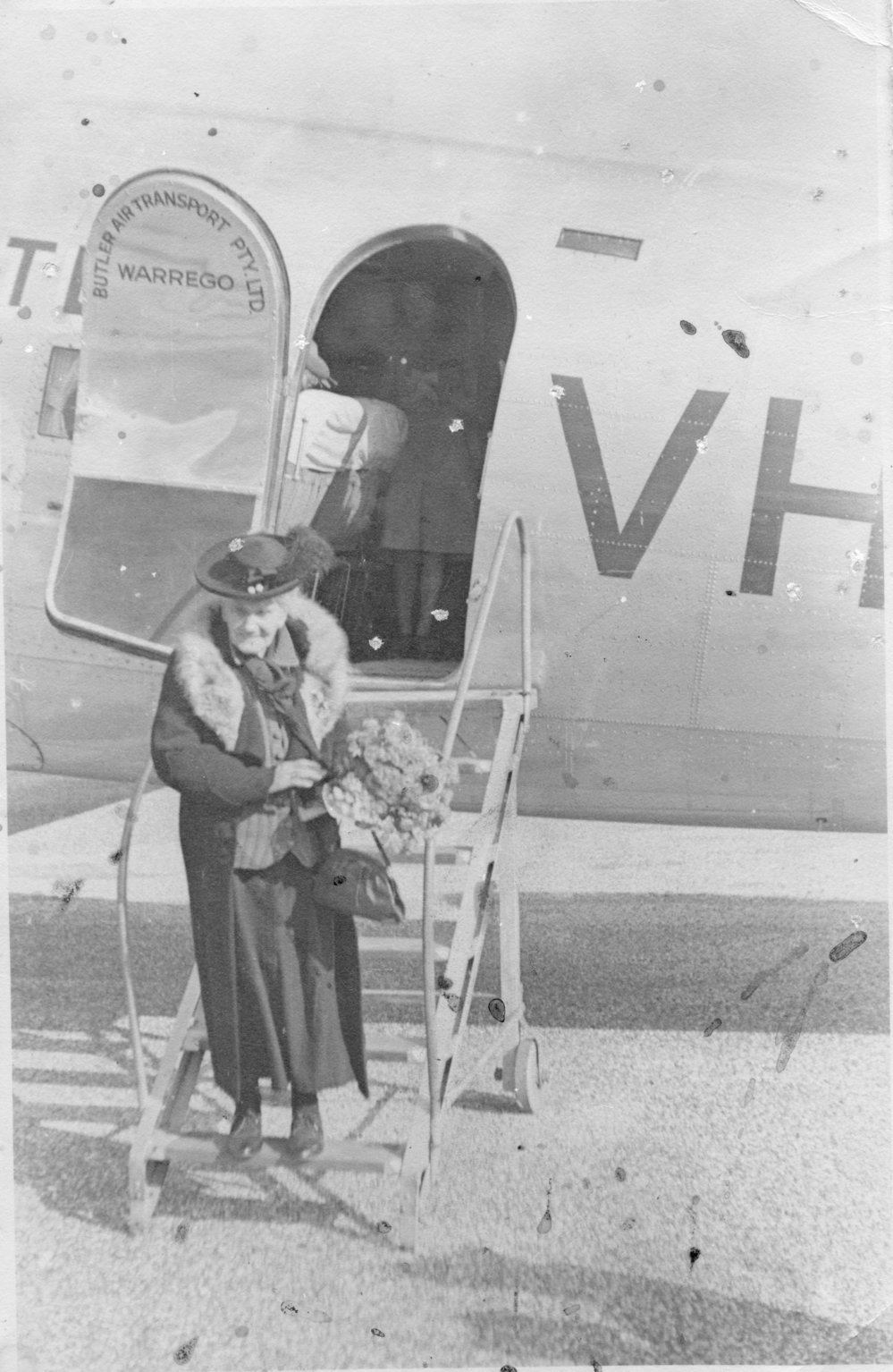 Elizabeth Buckler stepping off a plane following her first air flight, 1934 