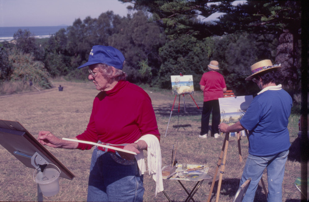 Three women painting 'en plein air' by the beach