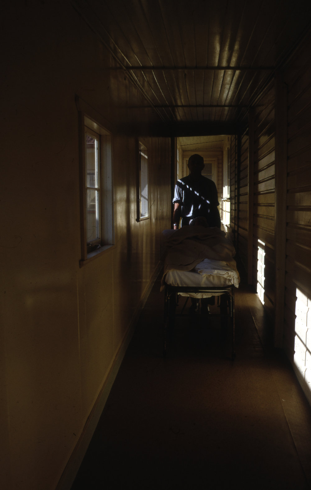 Theatre corridor at Coffs Harbour District Hospital with nurse and body, September 1969