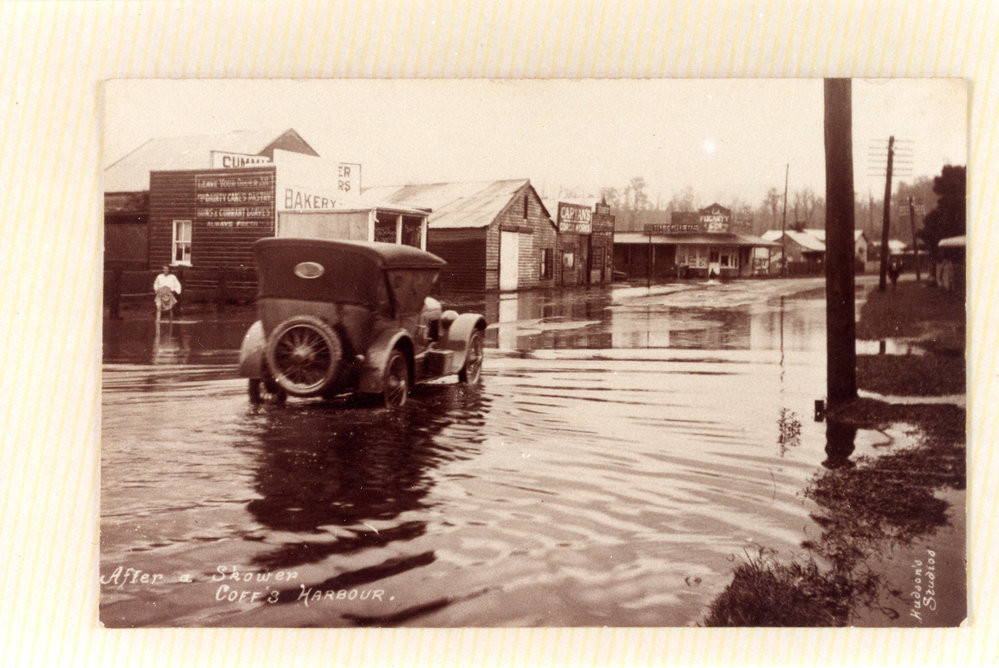 A car drives by the corner of West High Street and Lyster Street in flood waters, c. 1922 