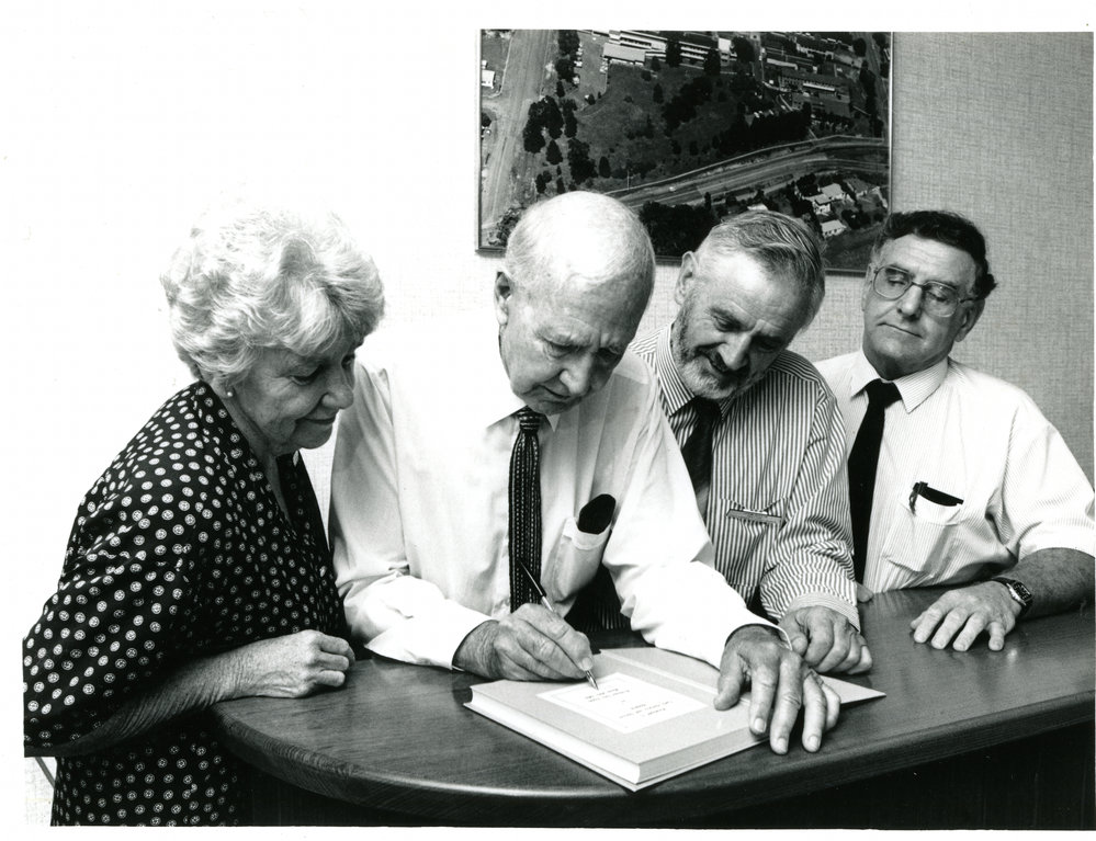 Neil Yeates signs a copy of his Coffs Harbour history, 1990