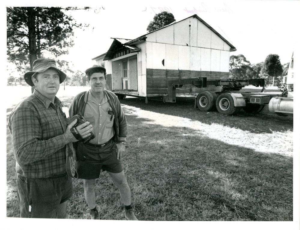 Two men moving a house