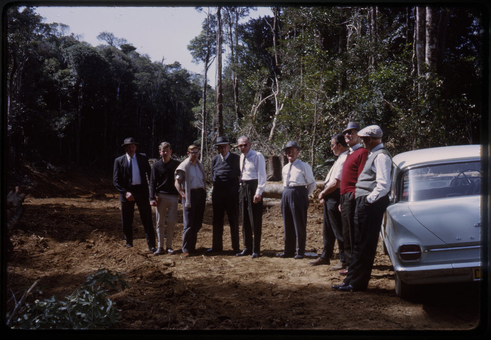 Group of men on dirt road, c. 1963