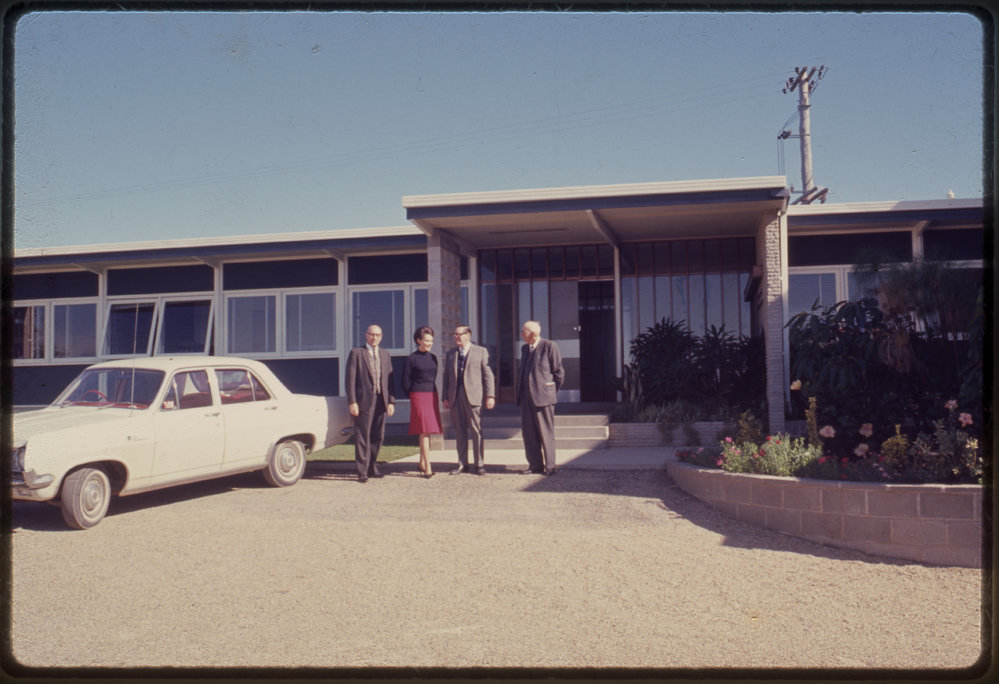 Group of people in front of building, c. 1966