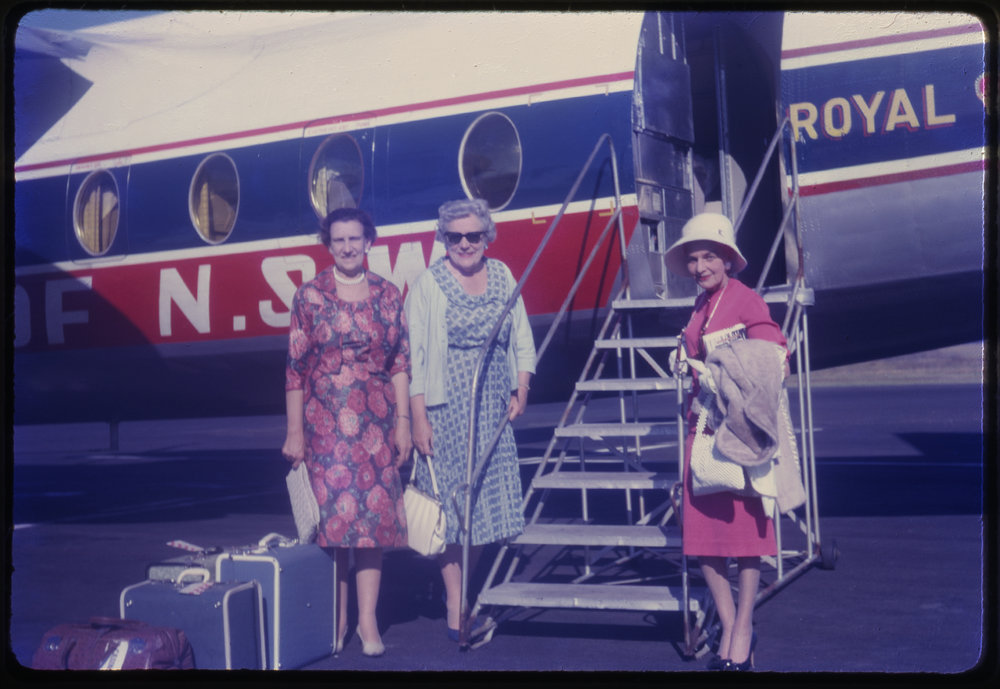 Three women about to board airplane, c. 1962