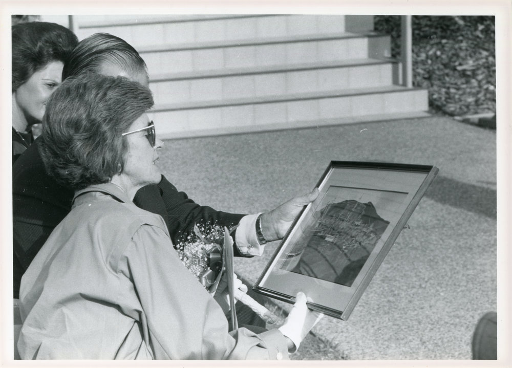 Lady Rowland admires a painting of the marina, 18 April 1985