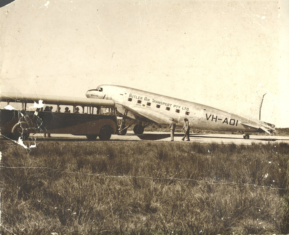 Butler Air Transport's DC3 Royal Mail plane "Warrina" is met by a town bus.