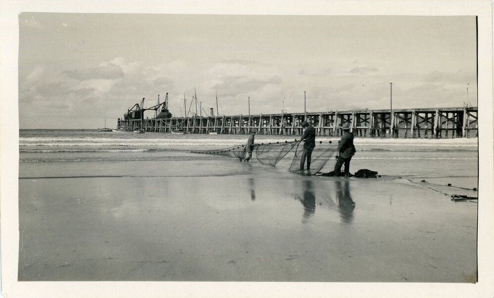Netting fish on Park Beach in Sunday best, early 1930s