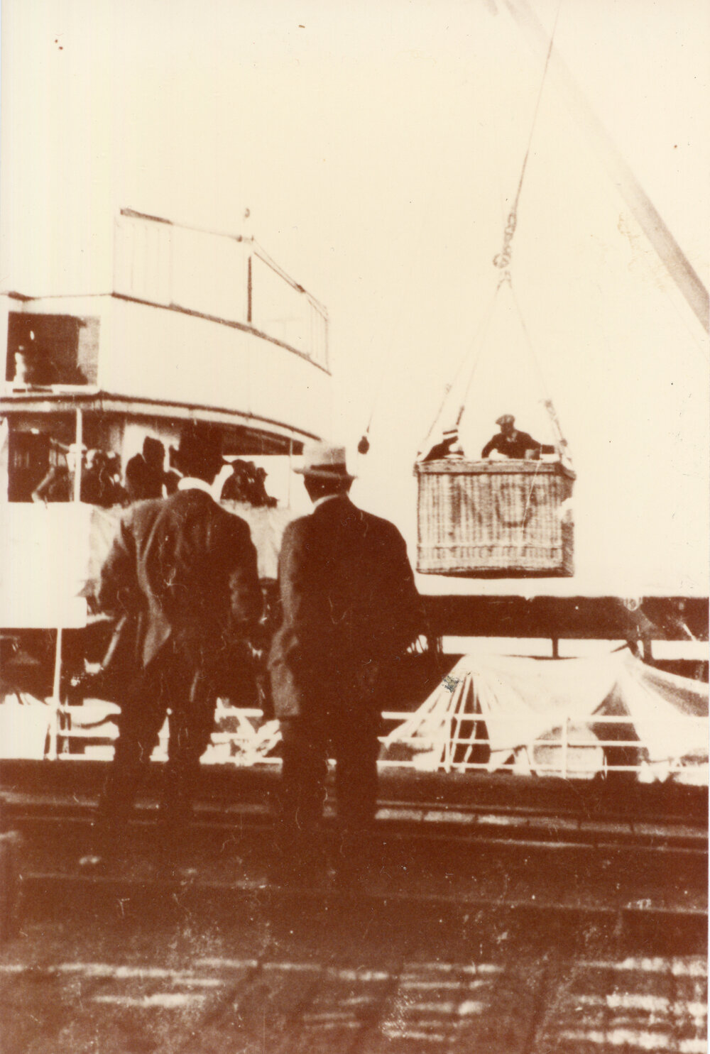 Passengers landing via a basket attached to a crane at the end of the Jetty, 1920s