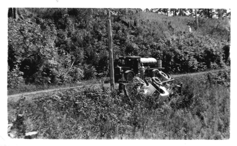 David Nicol looking at an overturned lorry where the road side gave way, 1938 