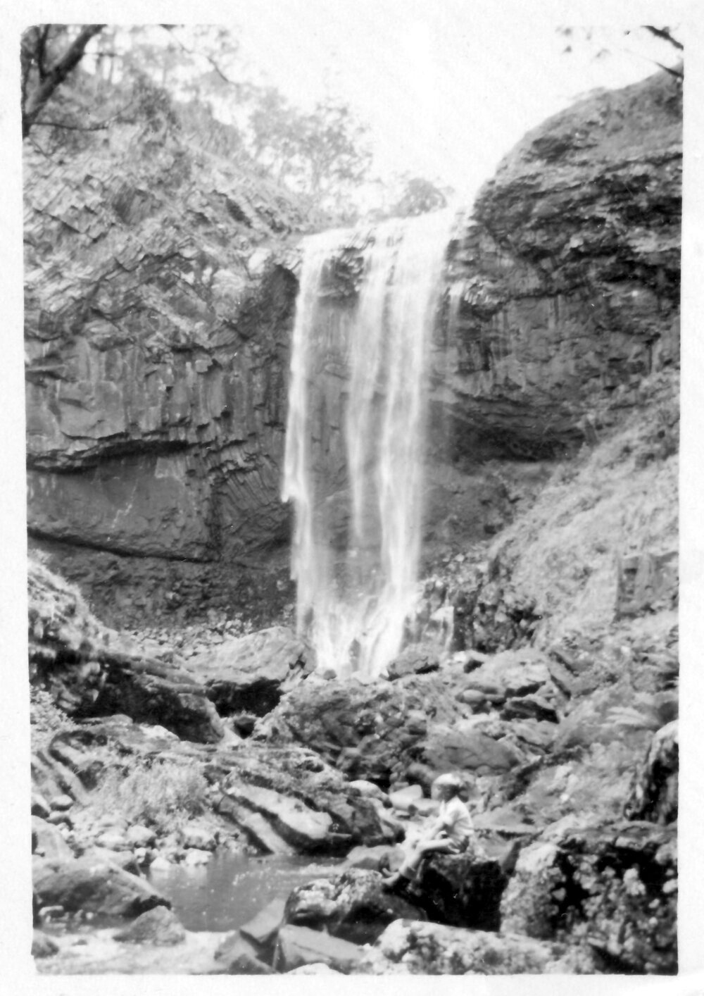 Robert Nicol sitting below the second falls at Ebor, 1940s 