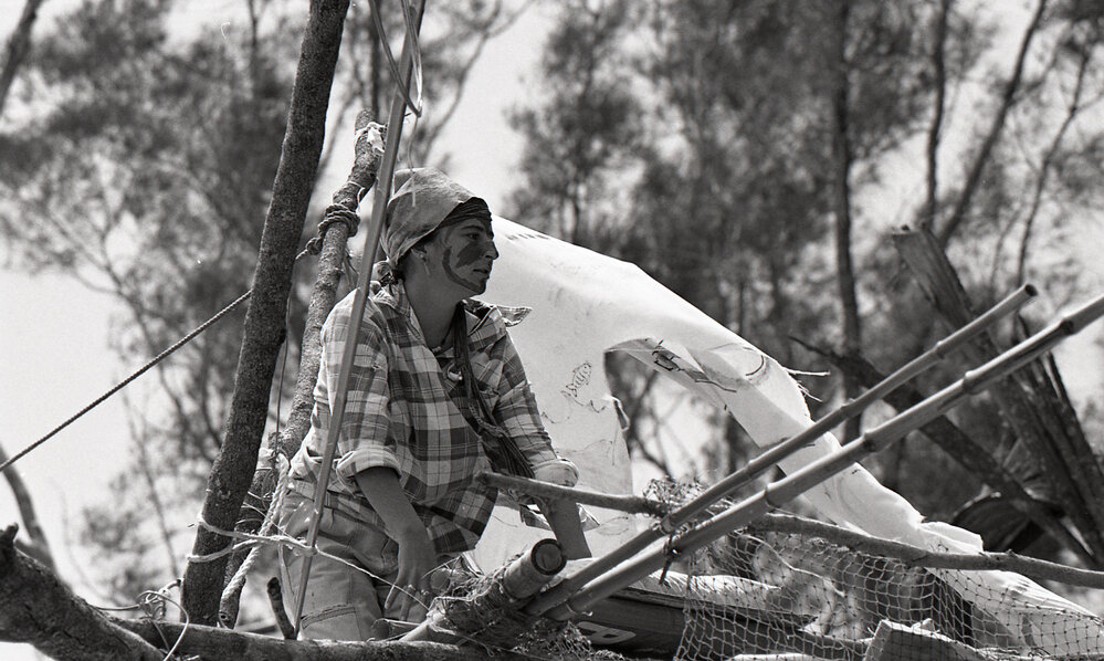 A protestor perches on top of a teepee, 25 November 1991