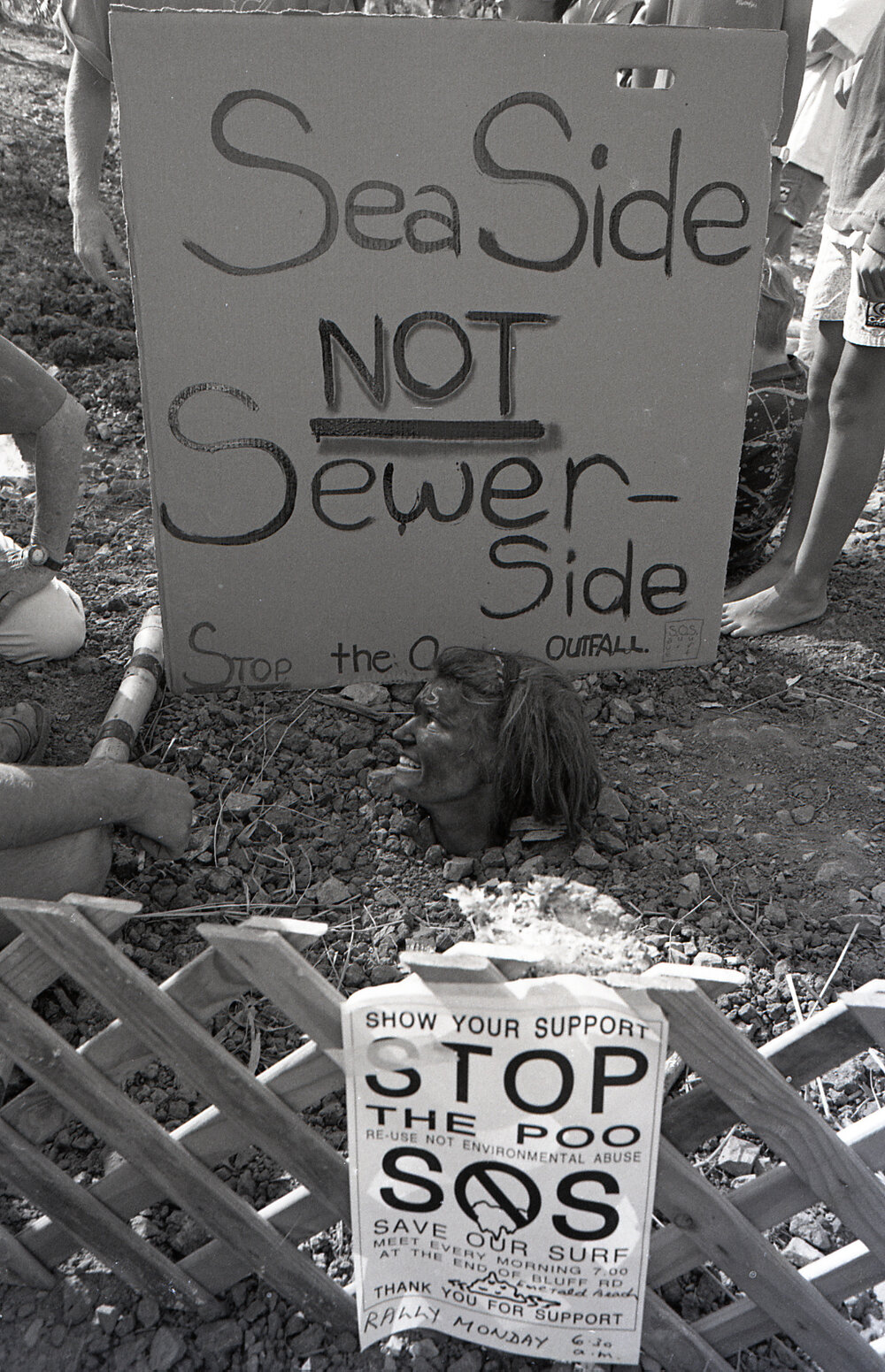 A protestor is buried up to her neck, late 1991