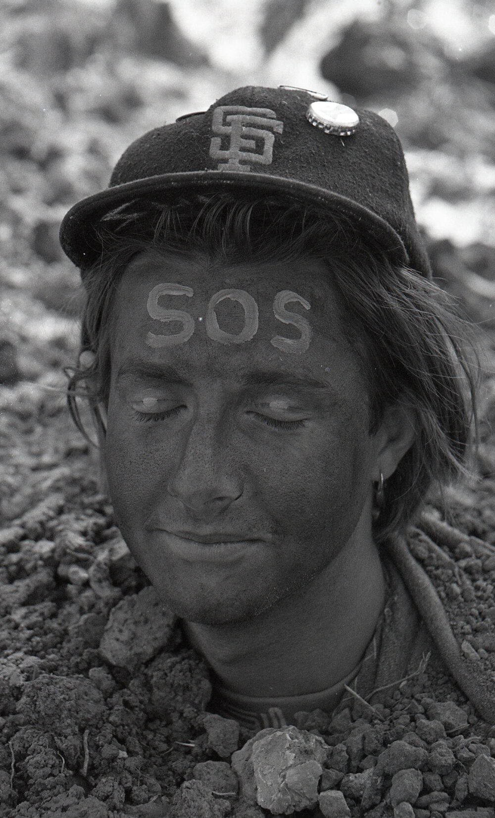 A protestor is buried up to his neck in the sand, late 1991