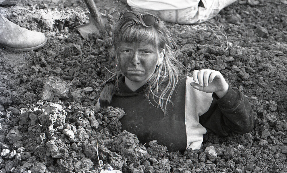 A protestor is buried up to her neck in the sand, late 1991