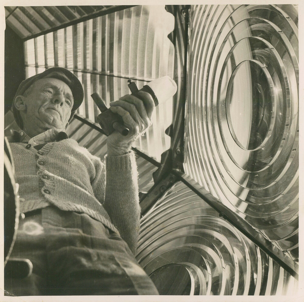 Head lightkeeper Jim Duncan inside the lighthouse optic on South Solitary Island, 1946