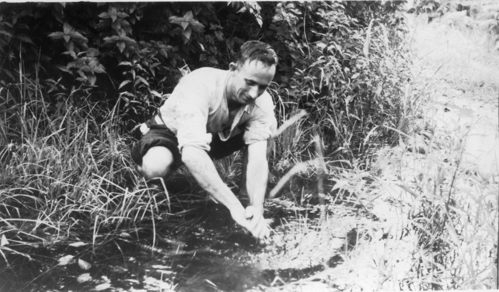 Chris Lewthwaite washing his hands in the creek, 1950