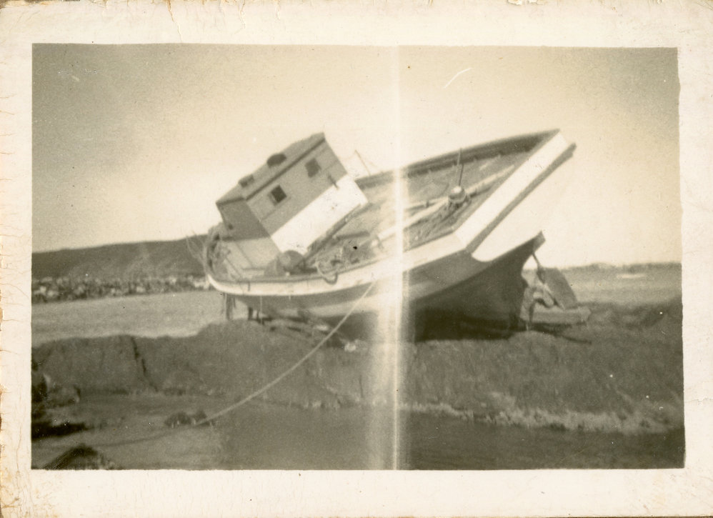 Local fisherman Syd Hardy's boat on rocks at the northern end of Jetty Beach, 24 June 1950 