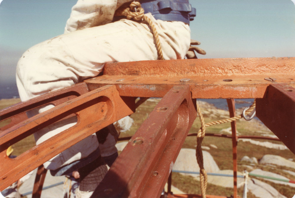 Workmen balance on top of the South Solitary Island Lighthouse