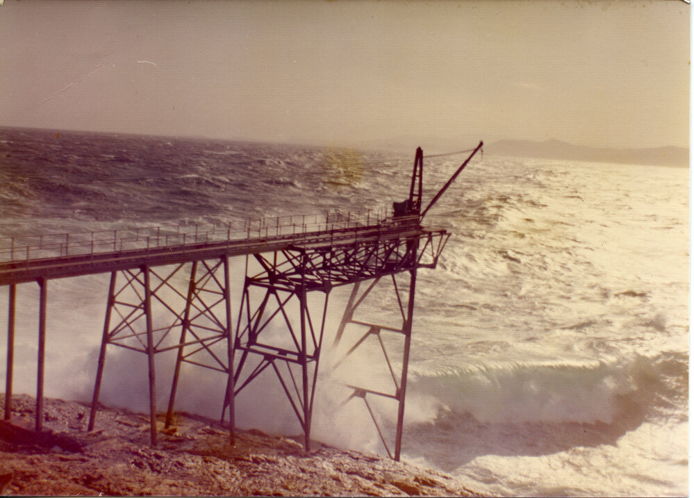Waves crash against the gantry at South Solitary Island, early 1970s