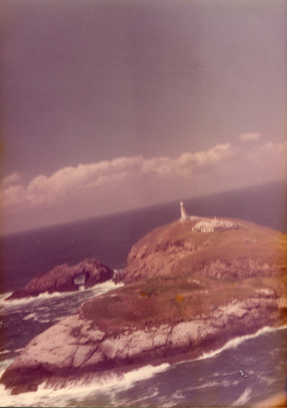Helicopter view of South Solitary Island Lighthouse and Arch Rock, mid 1970s