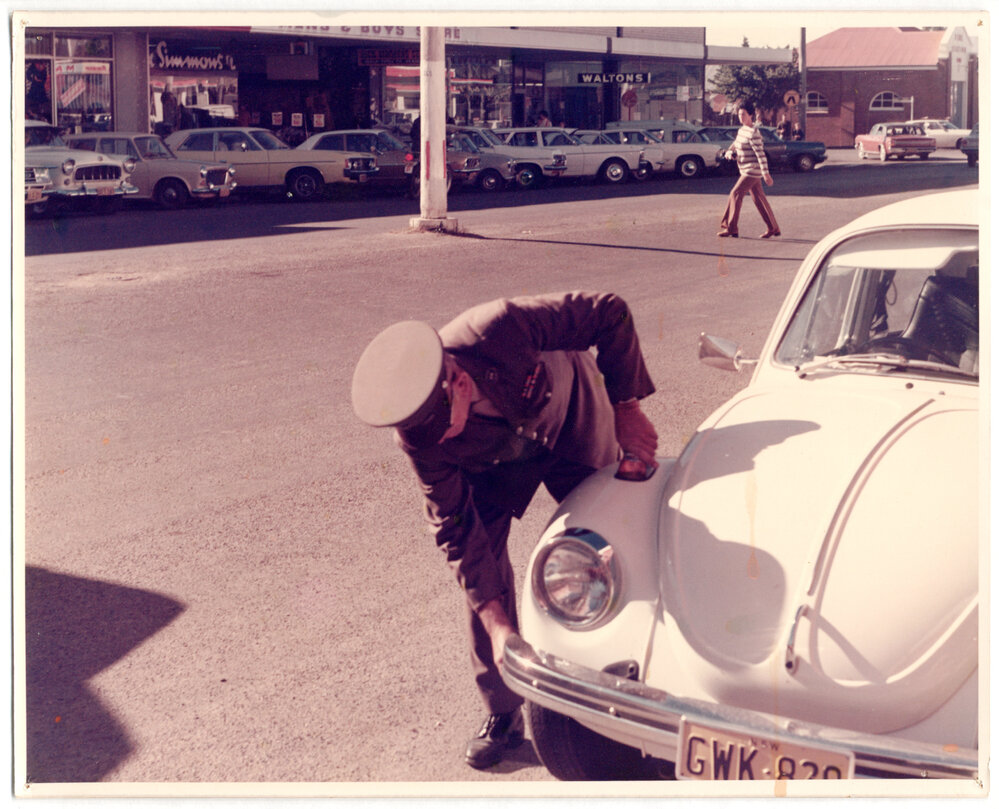 Parking officer marking tyres, corner of High and Castle Street, Coffs harbour, c. 1980s