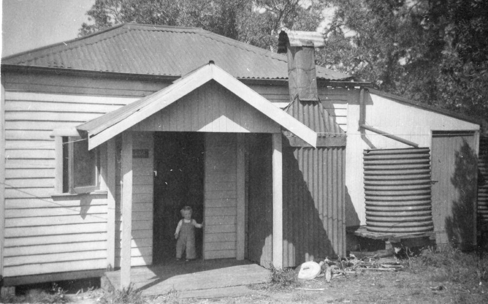 Child outside a house in Sawtell, 1958