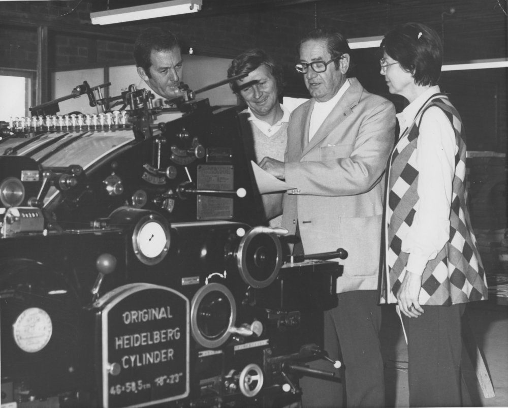 Arnold Forsyth and others check a Heidelberg Cylinder printing machine, June 1974