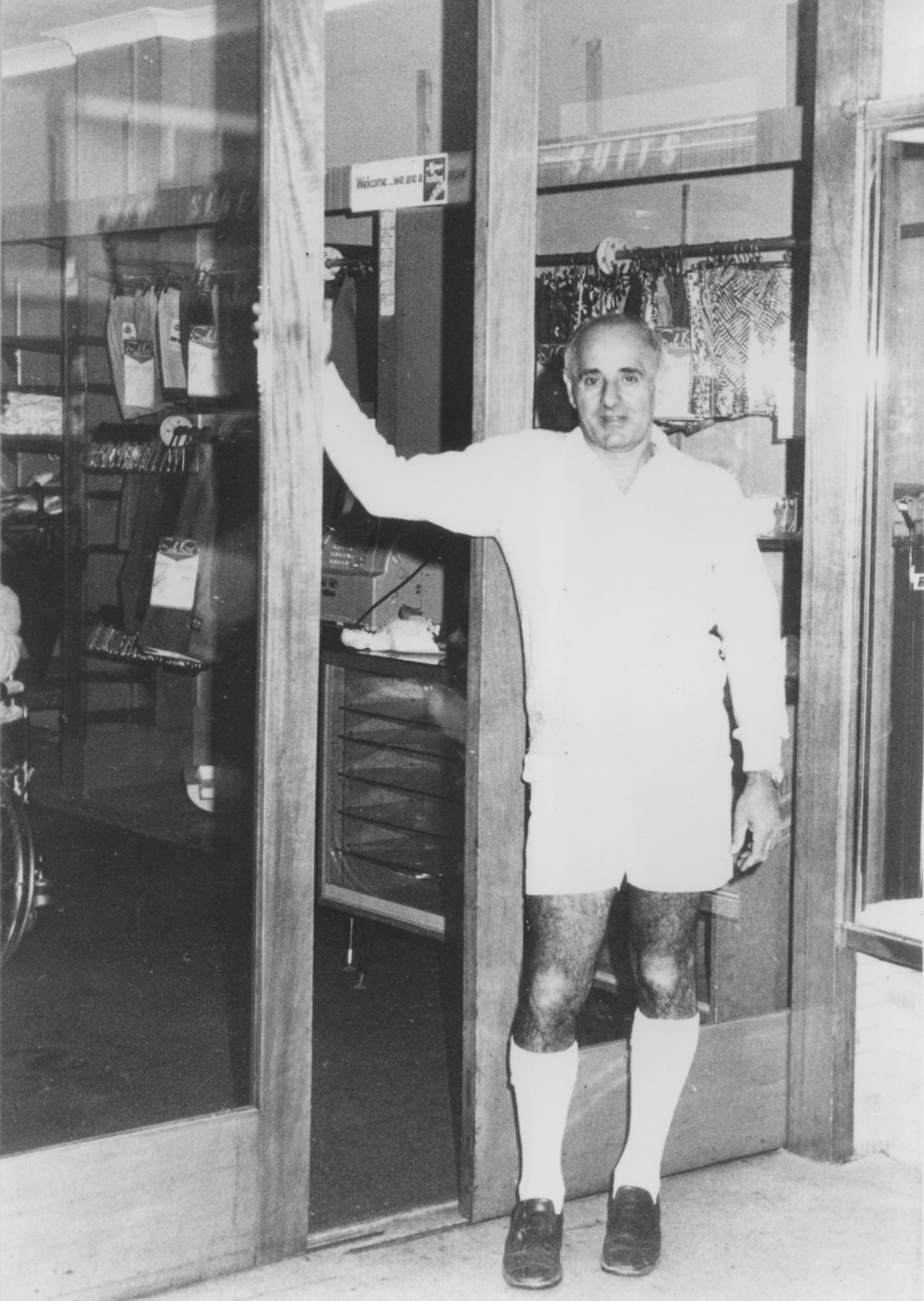 Bernie Malouf outside his menswear shop on its last day of trading, 1970s