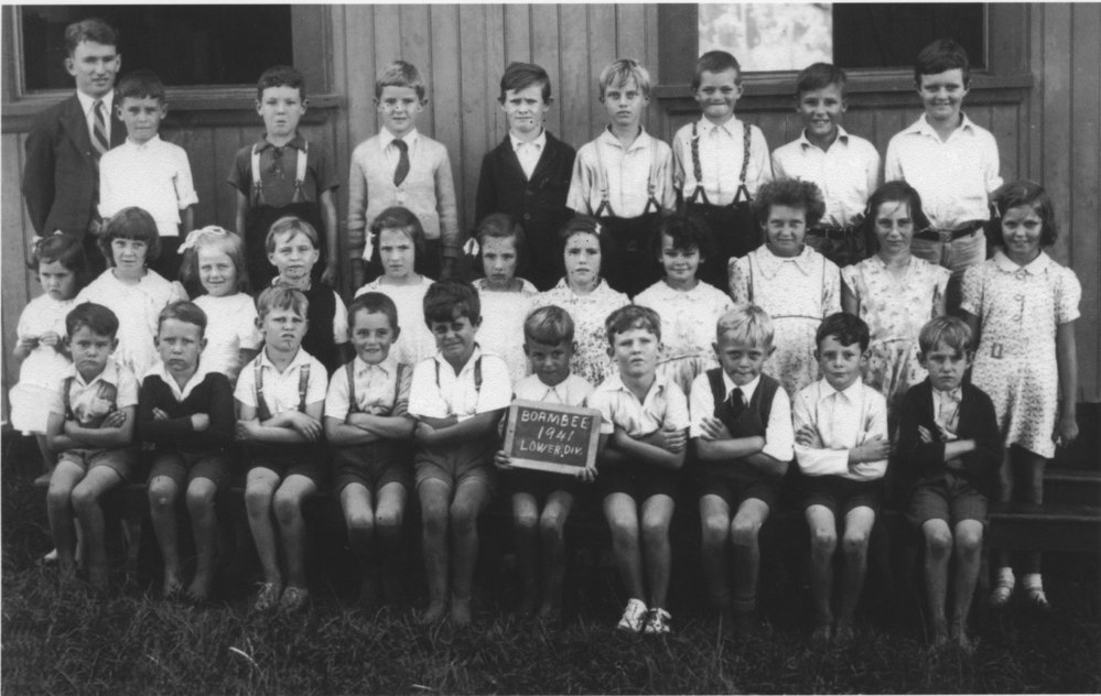 Assistant Teacher with students at Boambee Public School, 1941 