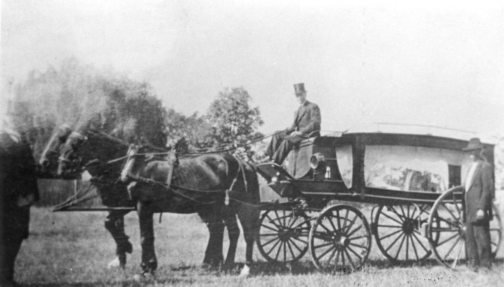 Harold Walker and undertaker C. H. Everingham with his horse-drawn hearse, 1920s
