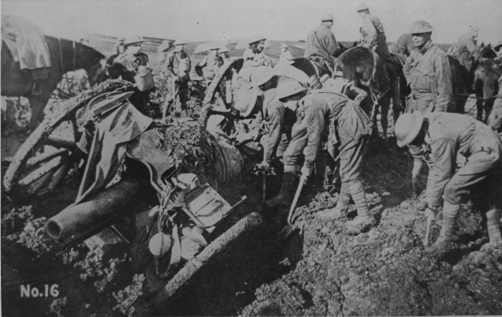Australian soldiers trying to move artillery mired in mud, 1917