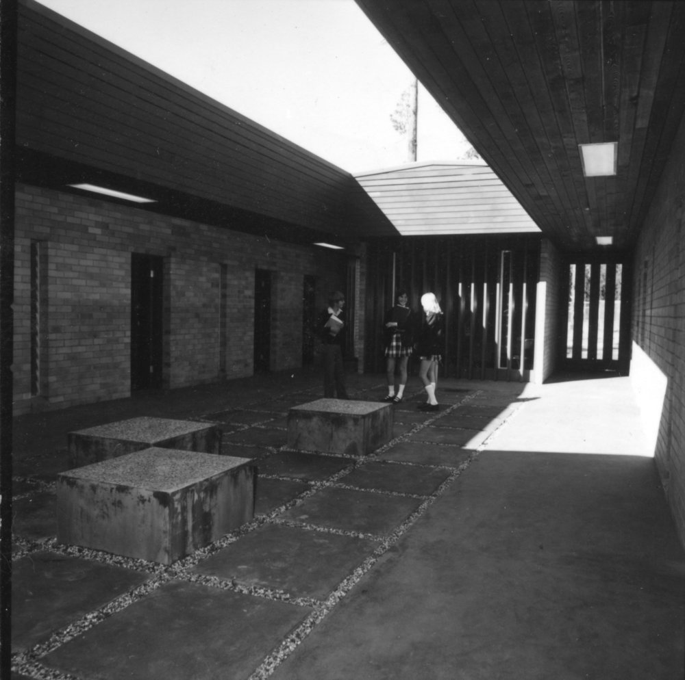 Three students standing in a courtyard at Orara High School, 1972