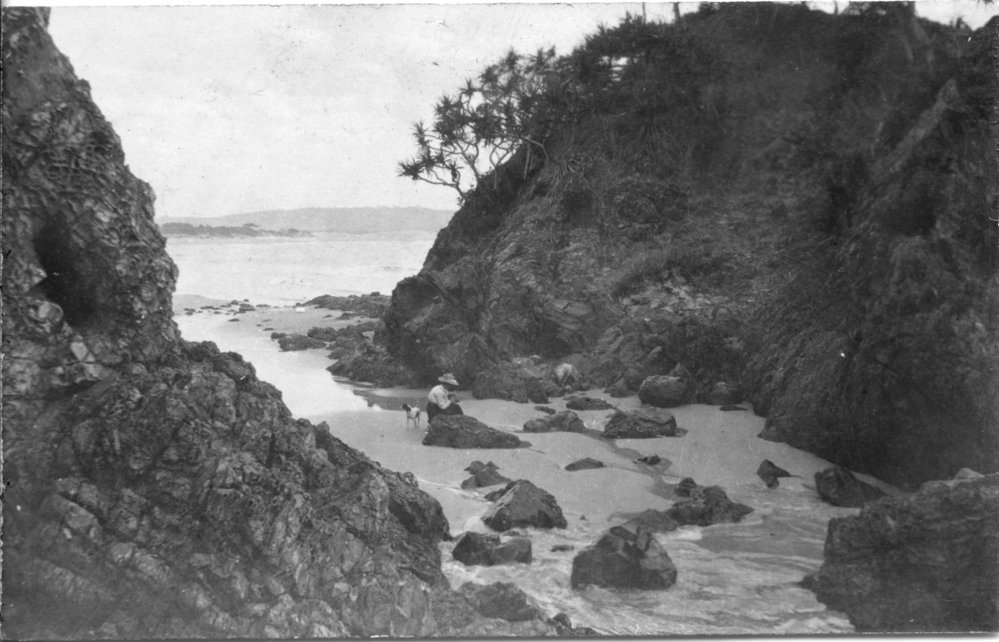 A woman and dog in a crevice at Moonee Beach, c.1912
