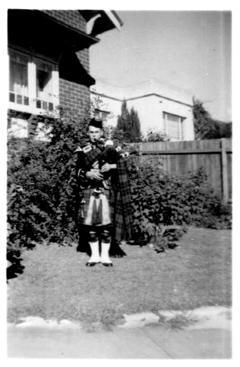 Hugh Nicol in full dress playing the bagpipes at Blaxland Road, 1959