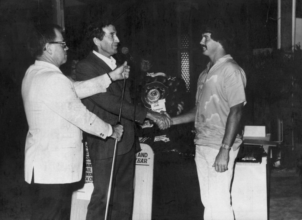 Bill Singleton and B. Bollinger presenting the Club Champion trophy 1980-1981 to Paul Worland, 1981