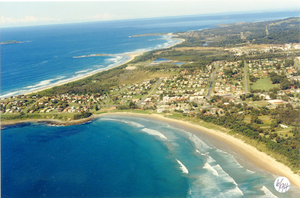 Aerial view over Woolgoolga CBD and Hearne's Lake, June 1994 