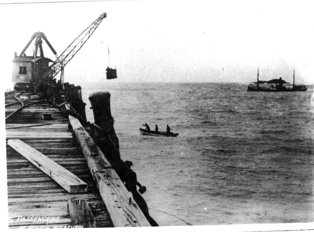Unloading passengers in rough weather from the boat by basket to Coffs Harbour Jetty, 1908