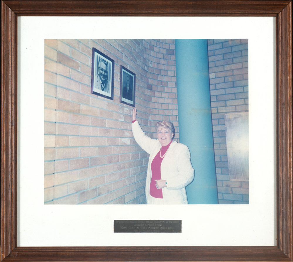 Barbara Wilson hanging photo of her father in Council Chambers, 1989