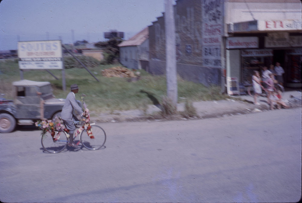 Cyclist on his decorated bicycle in a street parade at the Jetty strip, 1964