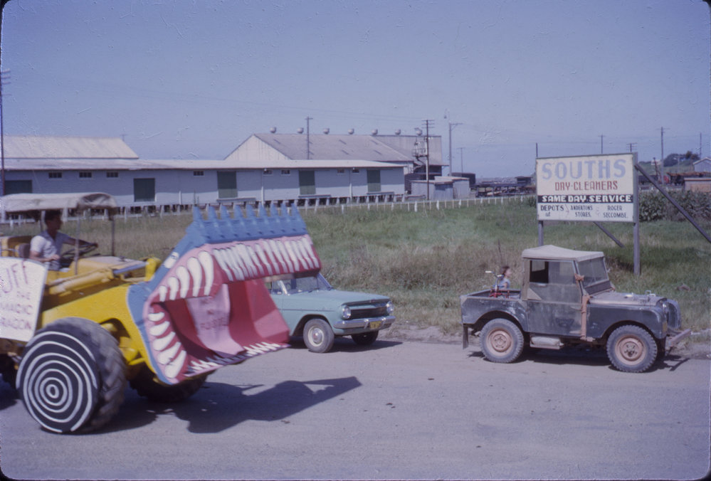Decorated backhoe in street parade, Coffs Jetty, 1964