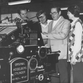 Arnold Forsyth and others check a Heidelberg Cylinder printing machine, June 1974