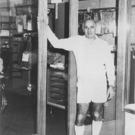 Bernie Malouf outside his menswear shop on its last day of trading, 1970s