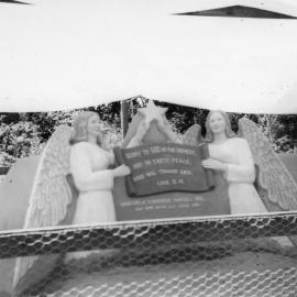 Sand sculpture of two angels holding a religious verse, 1962 
