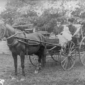 Family seated in a horse-drawn carriage, c. 1910
