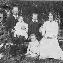 Portrait of Frank and Hetta Hoschke and their children sitting on a log, 1913 