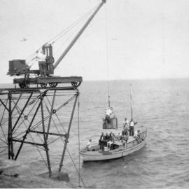 A gantry crane hoists a passenger basket from Alfred Platts' launch at South Solitary Island, 11 March 1934 