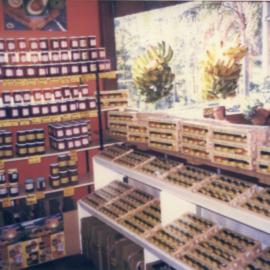 Condiments and bunches of bananas on display at the Tropical Fruit Shop, 1970s