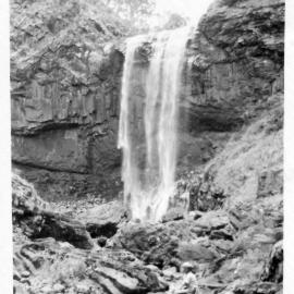 Robert Nicol sitting below the second falls at Ebor, 1940s 